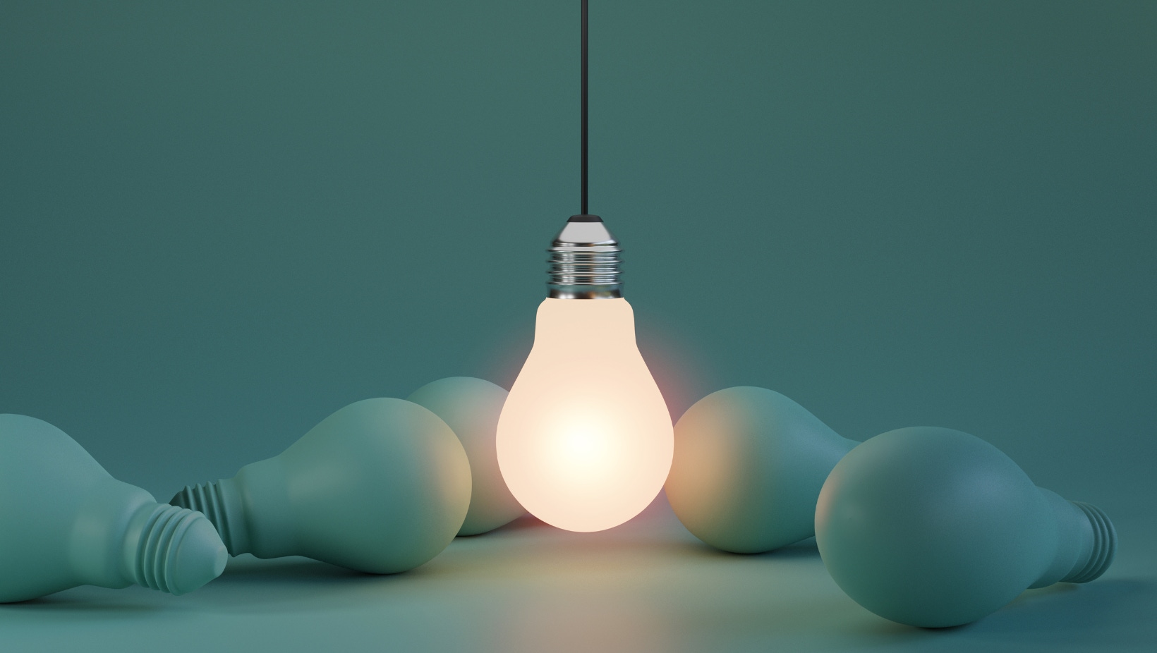 Image of several lightbulbs in a green tint with a single light bulb lit up in the centre